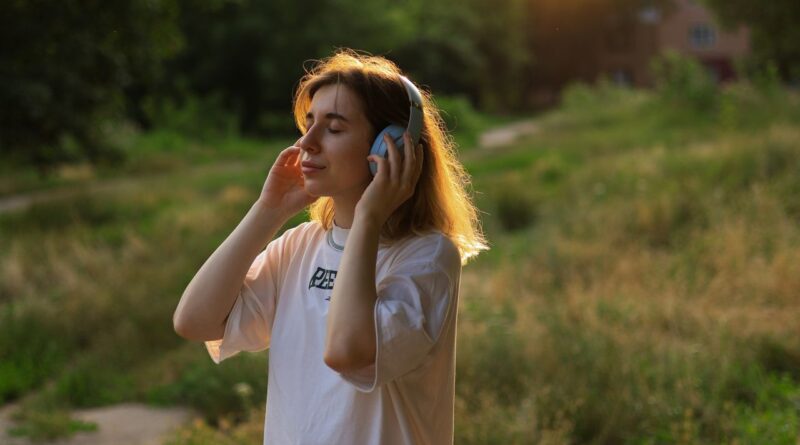 屋外でヘッドホンを使って音楽を聴く女性